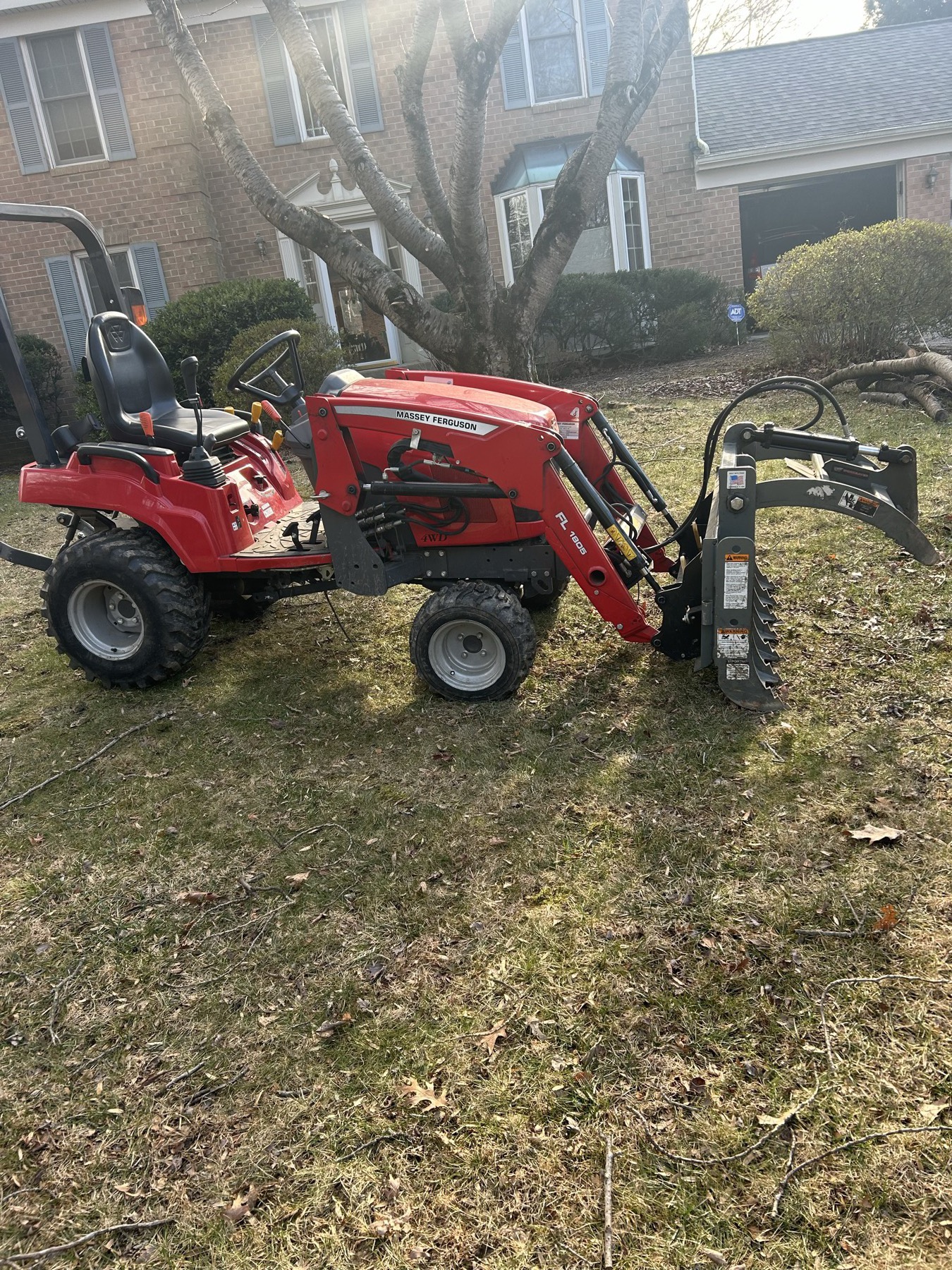 Red skid steer / compact loader owned by G&P on a residential property