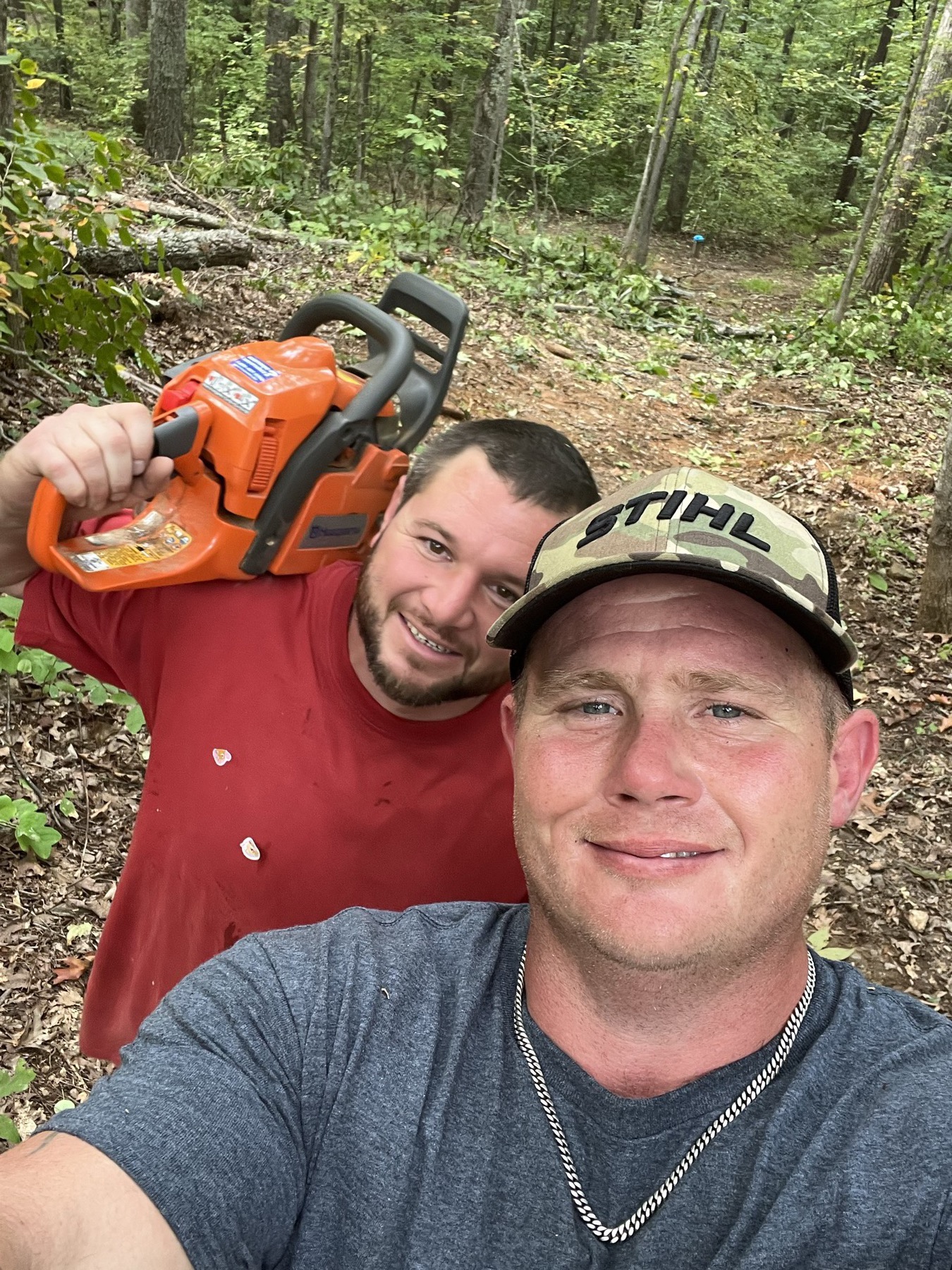 Bryan Graves and Robert Pruitt, G&P Tree Specialists owners, in the field with a chainsaw